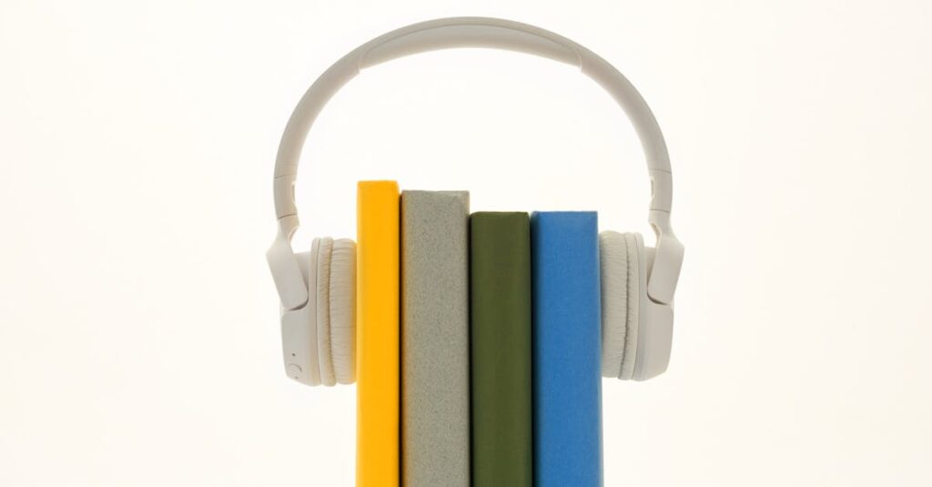 White headphones resting on colorful books, symbolizing modern audio technology.